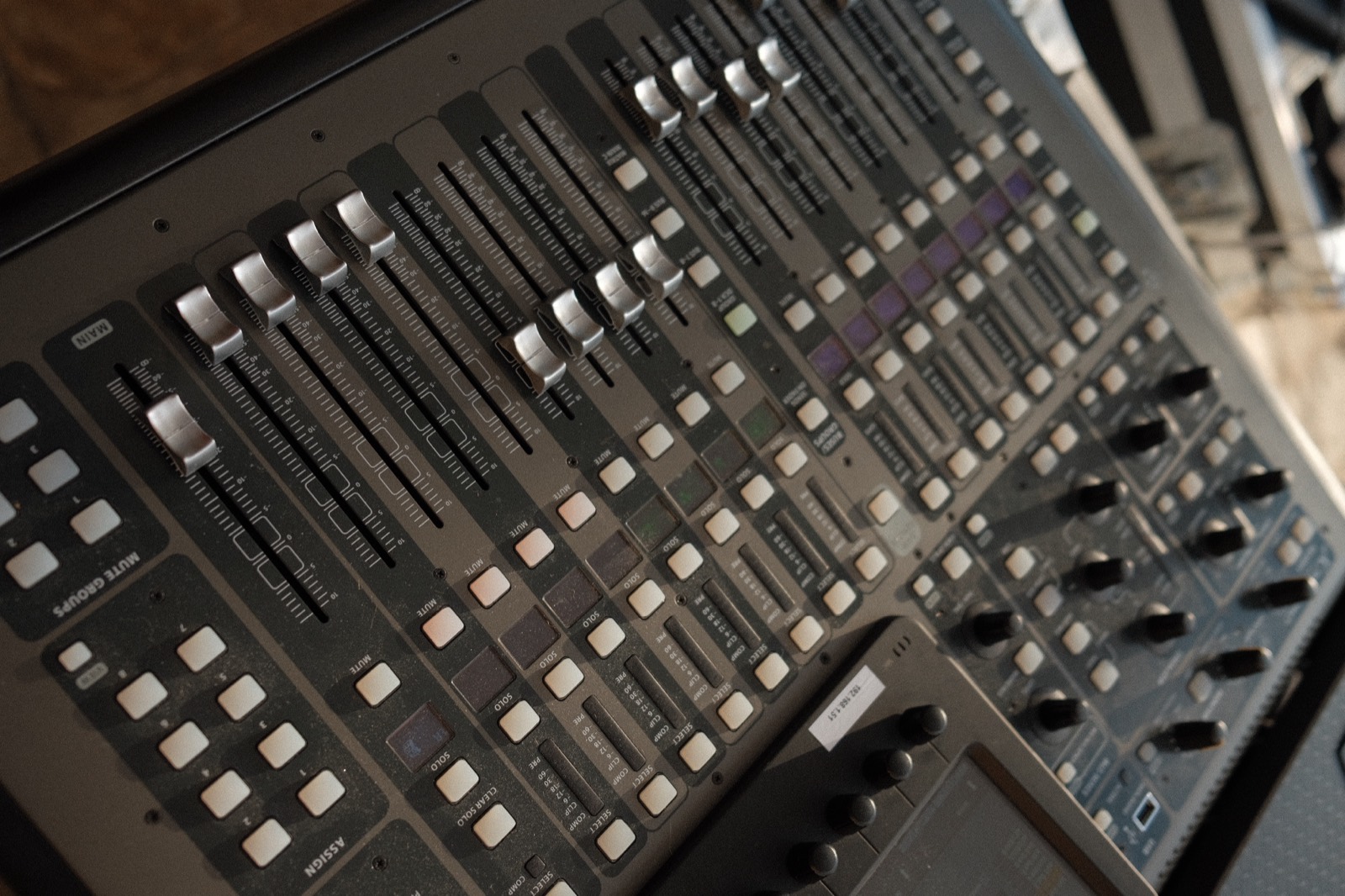 A mixing console with faders raised, capturing the live worship recording at The Hidden Encounter