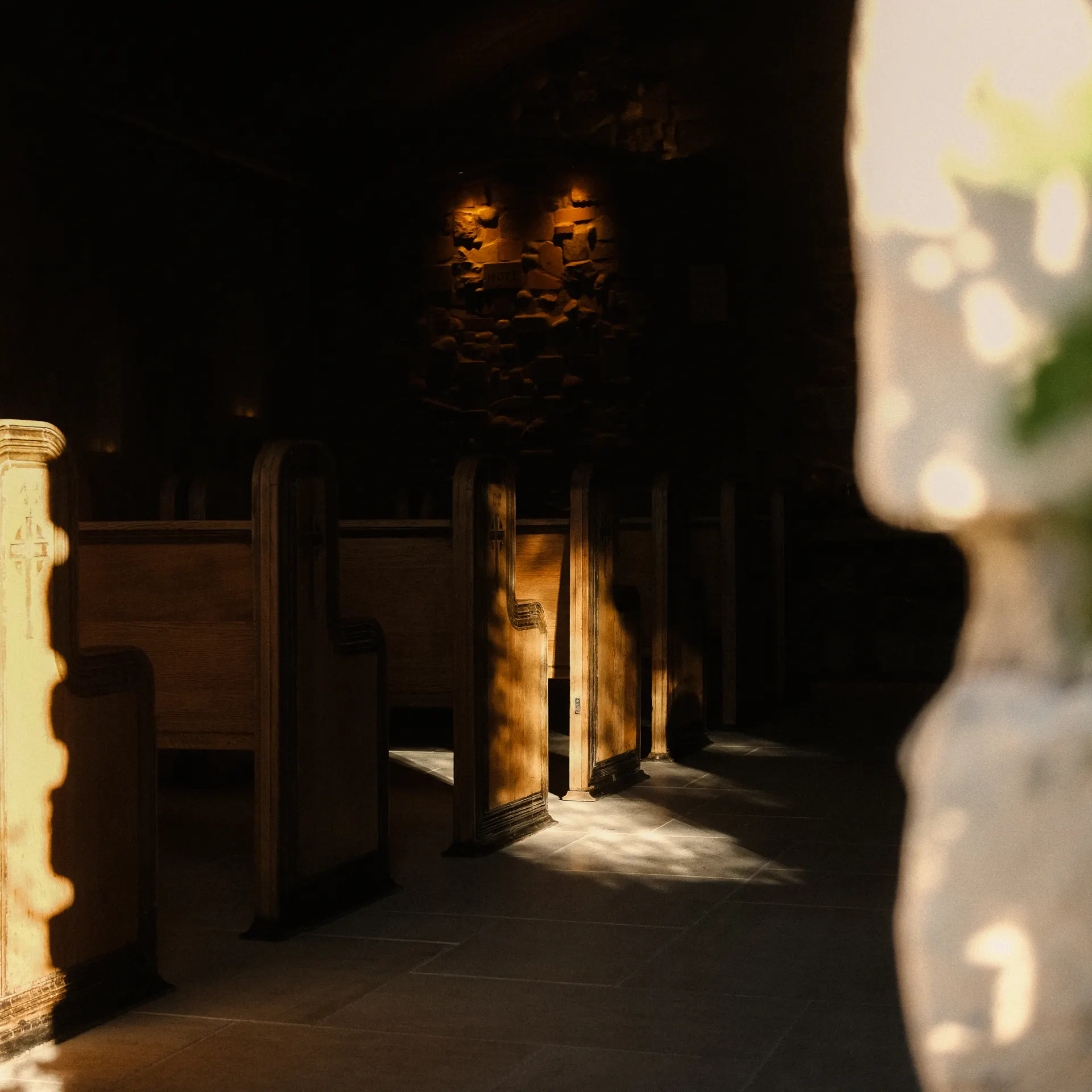 Chapel pew with carved cross in warm light, Zion Chapel, The Hidden Encounter