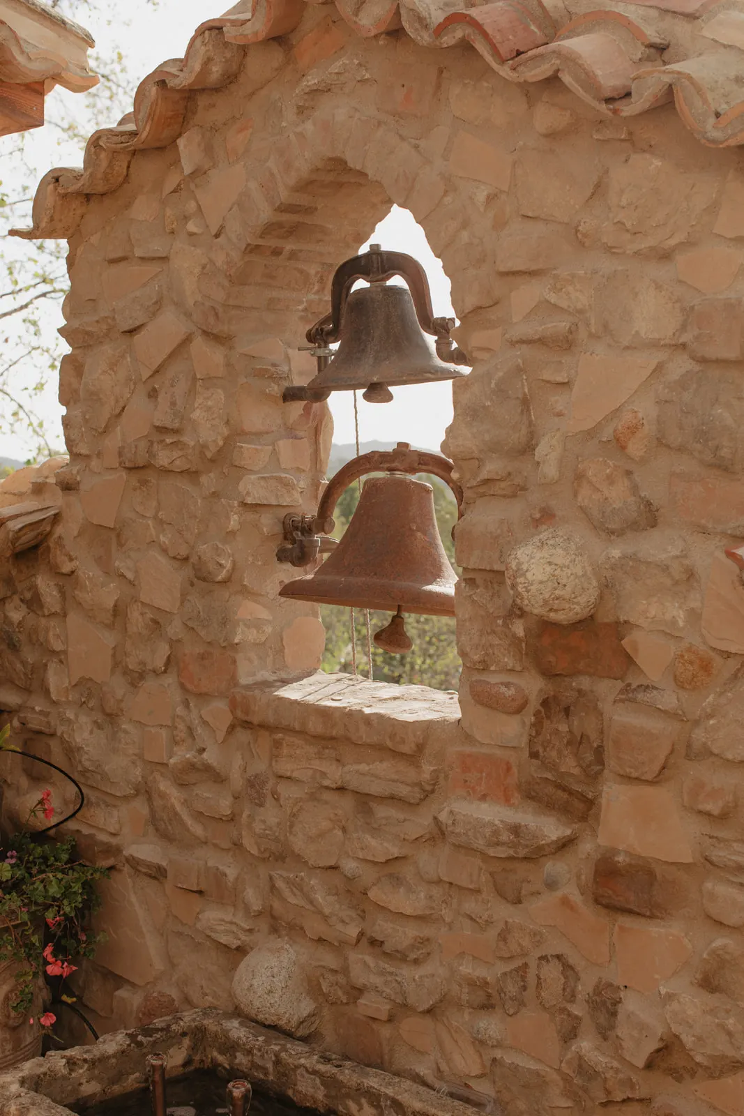 Stone archway with hanging bronze bells on the grounds of The Hidden Encounter