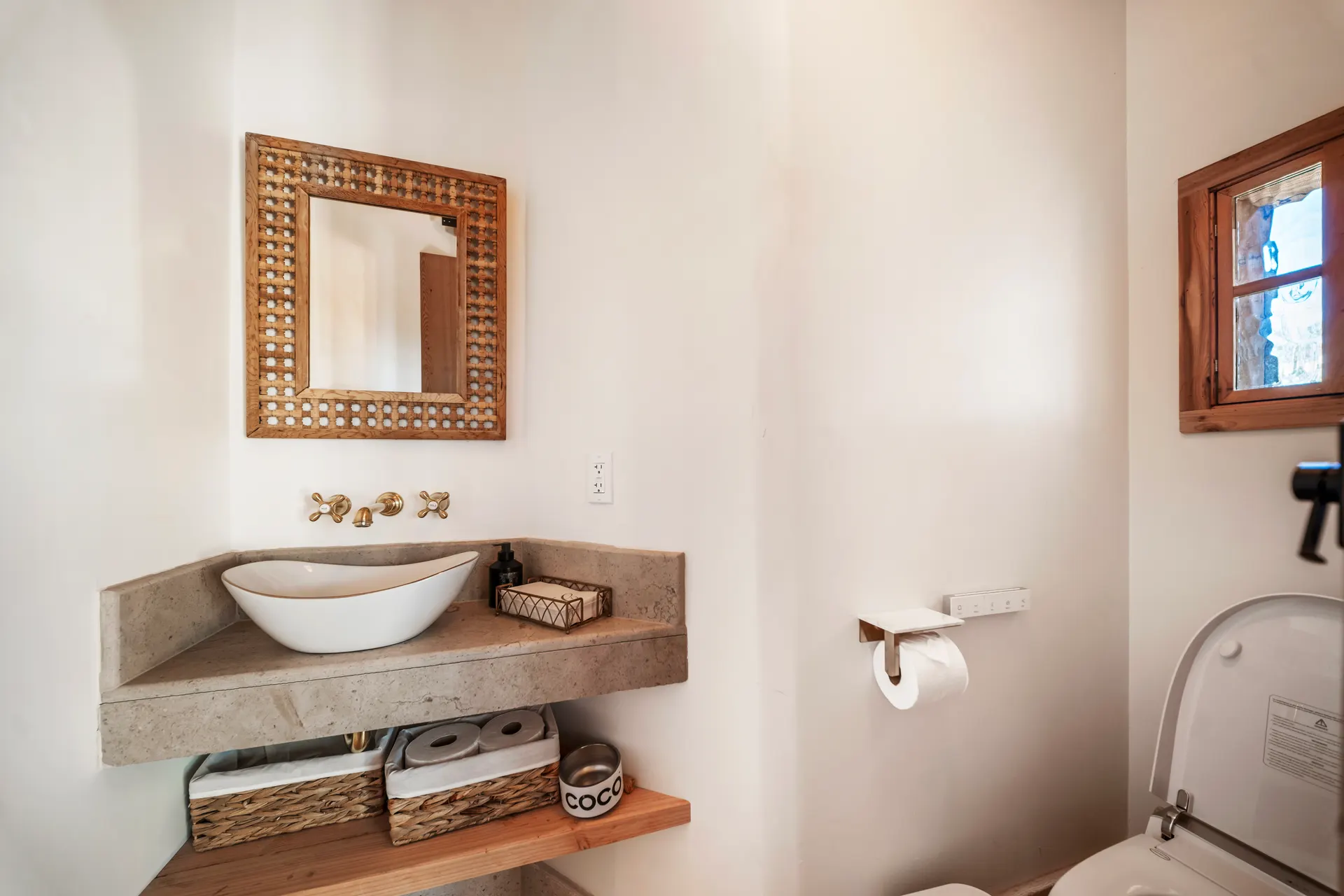 Stone vessel basin resting on a timber shelf, folded linens beneath