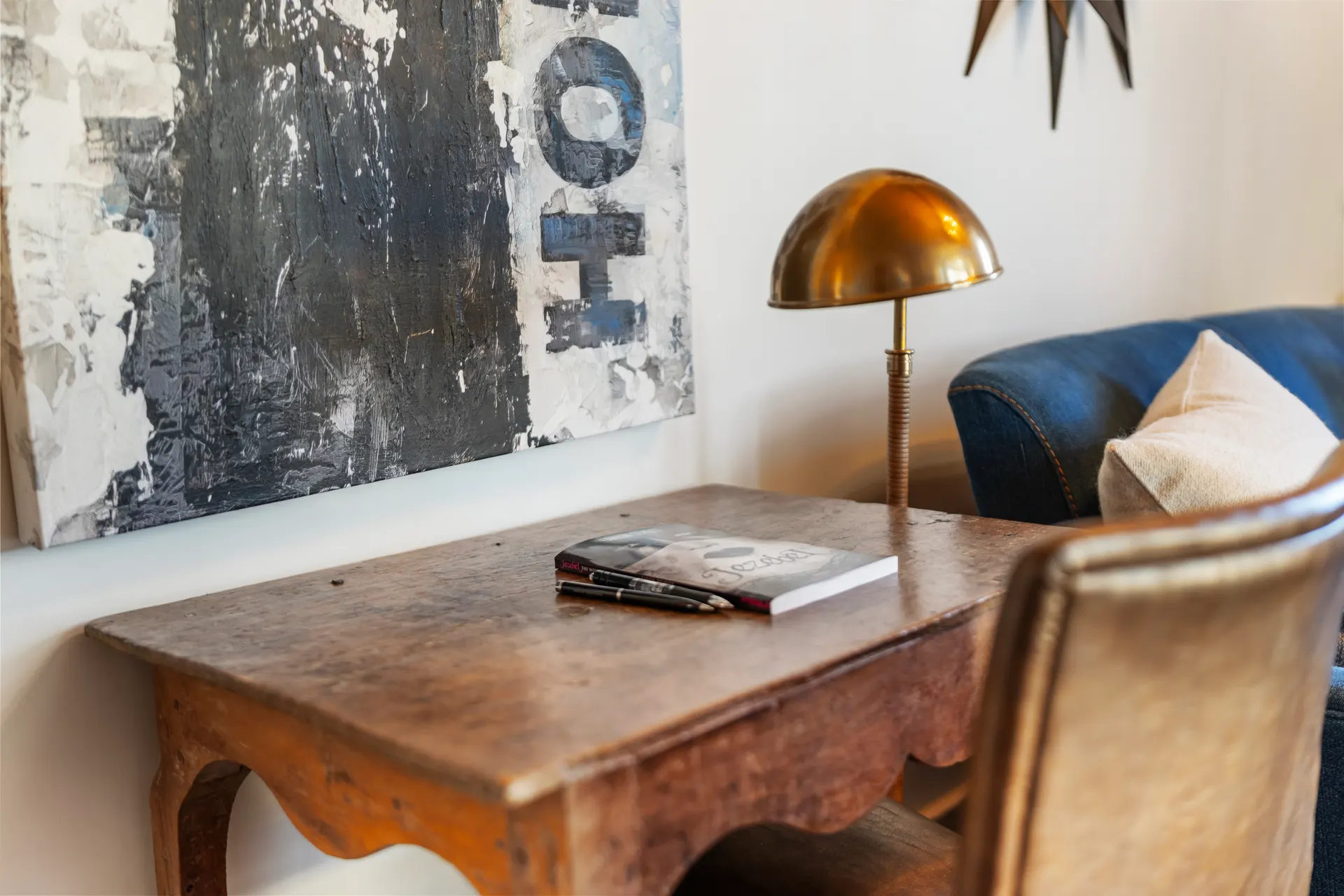 Writing desk with a brass lamp set beneath a large abstract canvas