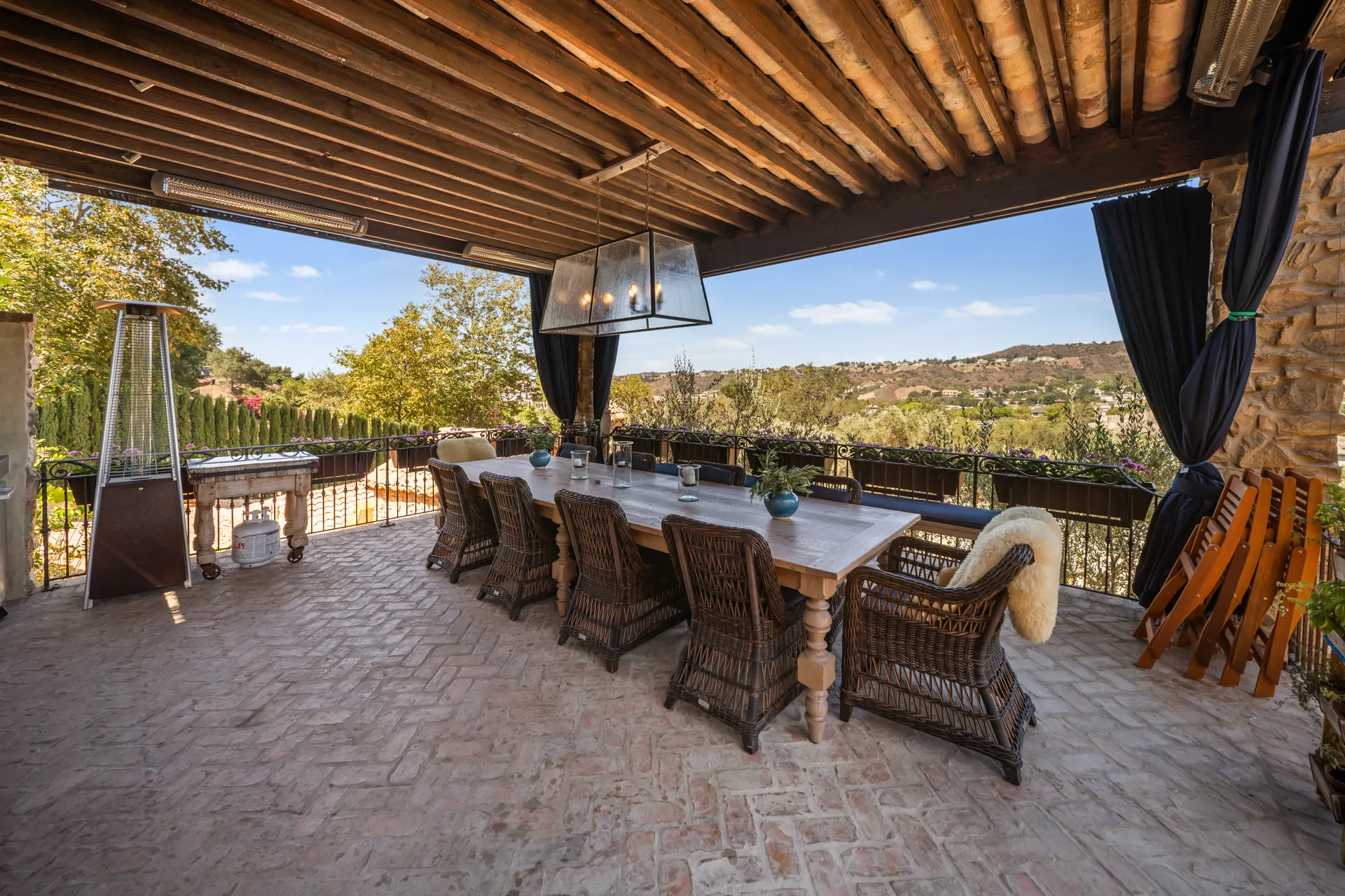 Table set the length of a covered pavilion, patio heater at the end, hills past the railing