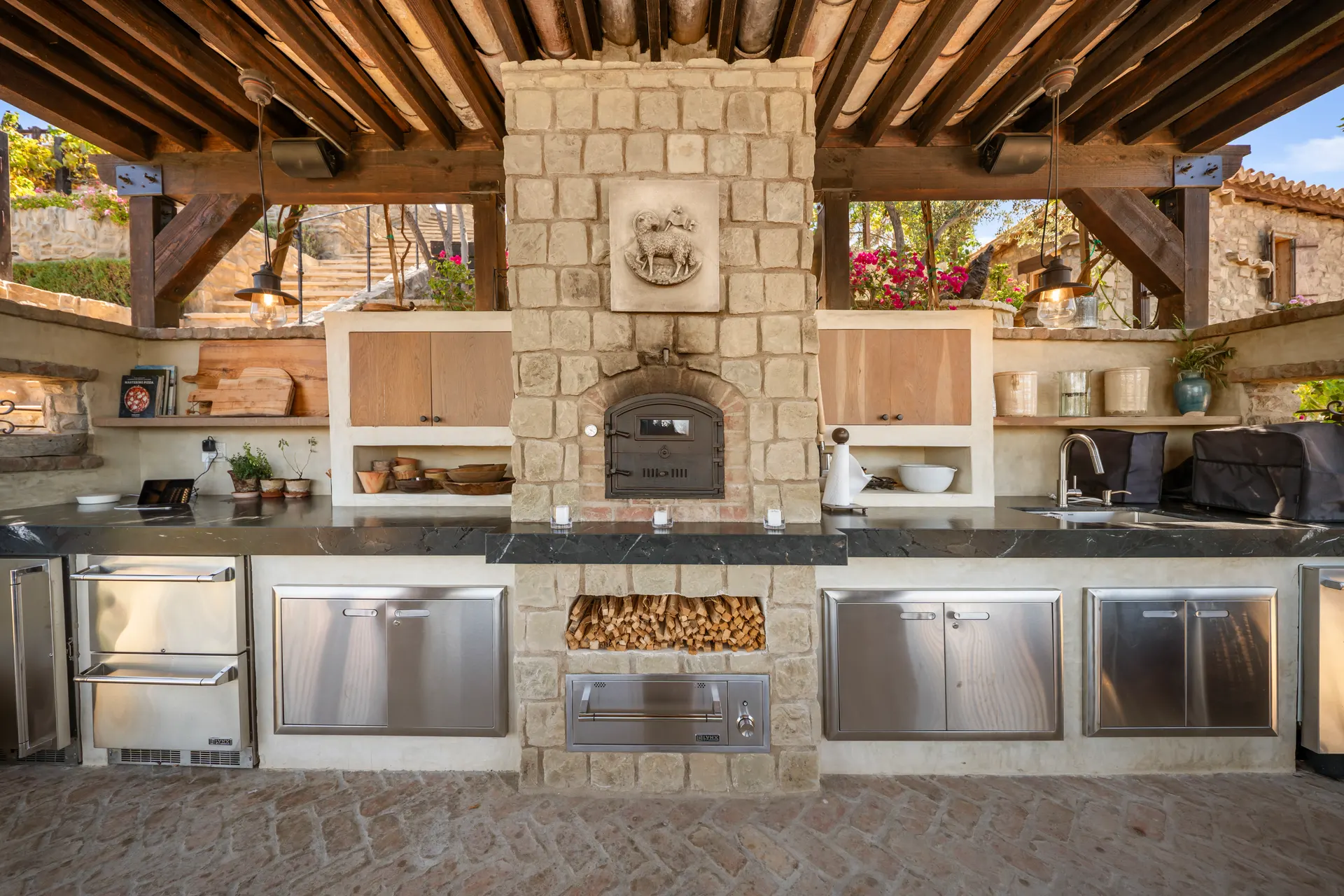 Stone chimney breast with a carved Agnus Dei relief above the hearth and oven