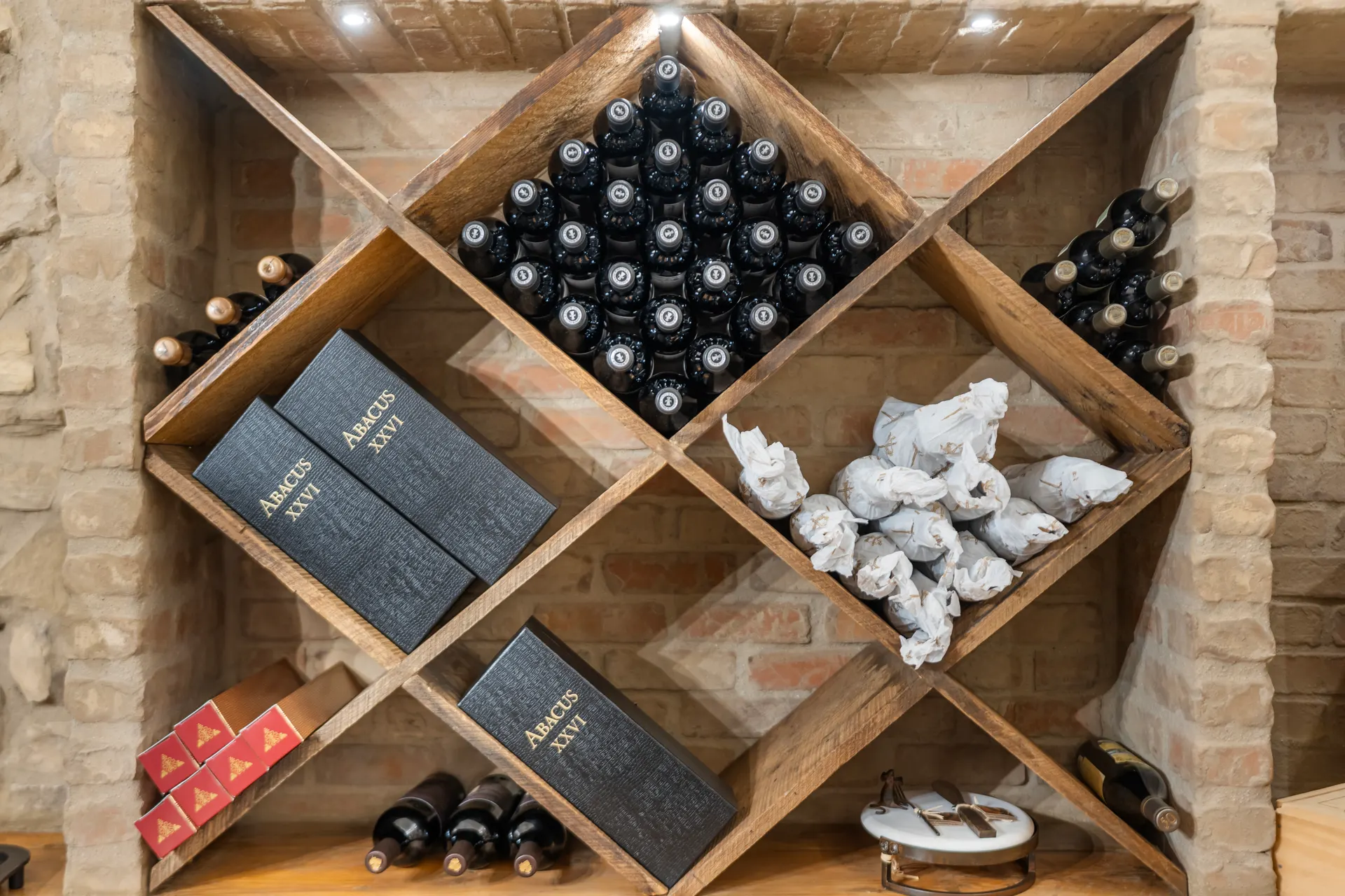 Diamond wine rack filled with bottles, boxed vintages stacked below