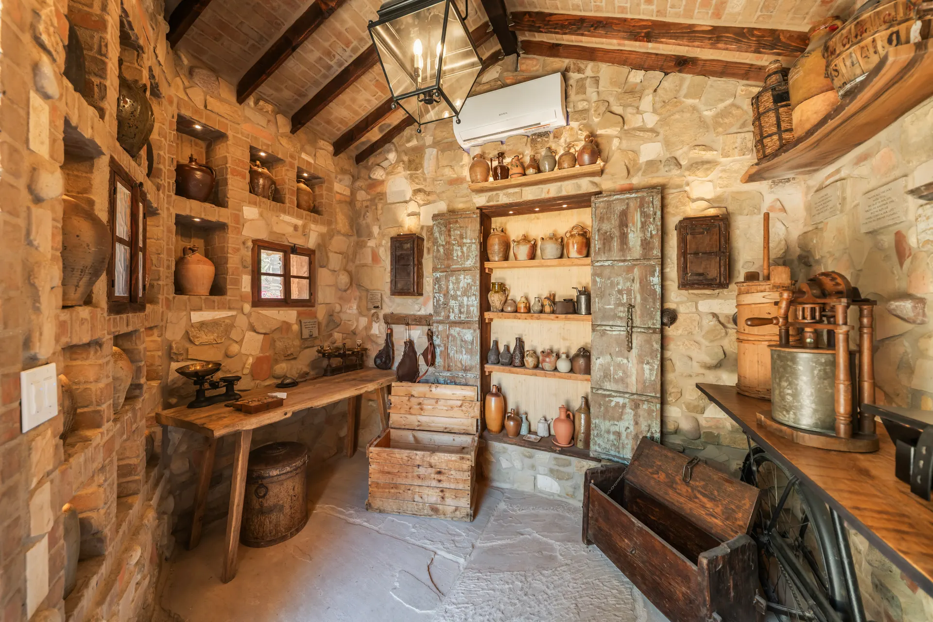 Shelves of glazed jars and crocks beside a weathered timber door